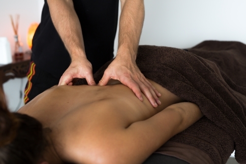 Close up of young woman back getting massage. Masseuse palms sports massage