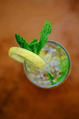 Close up overhead view of a cocktail or mocktail with ice, lemon and mint - Australian Stock Image