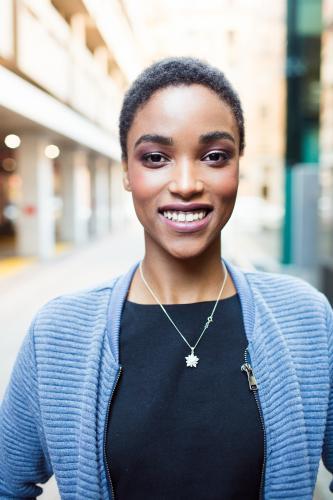 Close up portrait of a young woman smiling in the city - Australian Stock Image