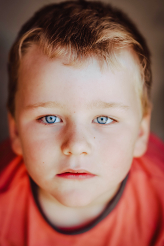 Close up portrait of blond caucasian boy with blue eyes - Australian Stock Image