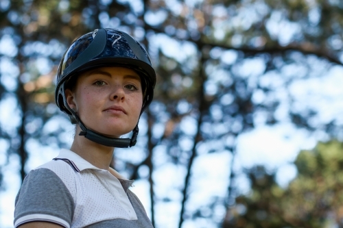 Close up portrait of young female horse rider wearing helmet - Australian Stock Image