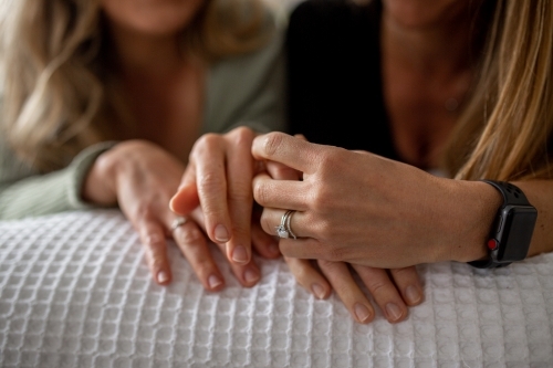 Close up shot of a women's hand holding each other with wedding rings - Australian Stock Image