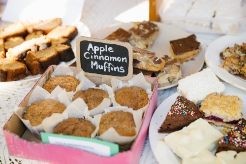 Close up shot of apple cinnamon muffins in a pink box with different pastries  around it - Australian Stock Image