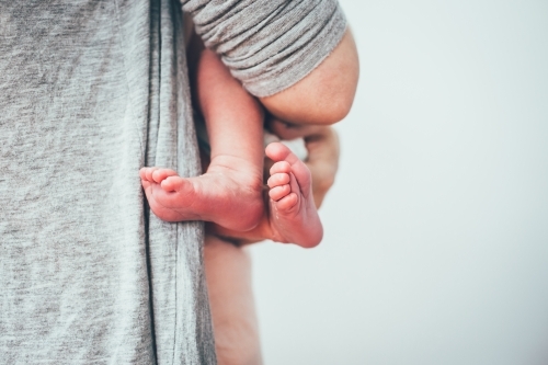 Close up shot of baby's feet and man holding the baby - Australian Stock Image