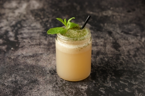 Close up of tomi punch with black straw and mint - Australian Stock Image