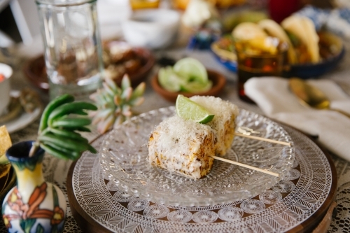 Close up shot of two cobs of chargrilled corn topped with cheese and lime - Australian Stock Image