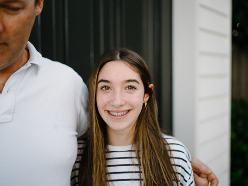 Closeup of a young teenage girl standing beside her dad. - Australian Stock Image