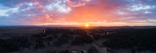 Clouds and sunset couloured sky over rural paddocks - Australian Stock Image