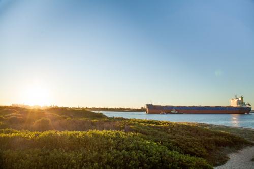 Coal ship coming into Newcastle Harbour at sunset - Australian Stock Image