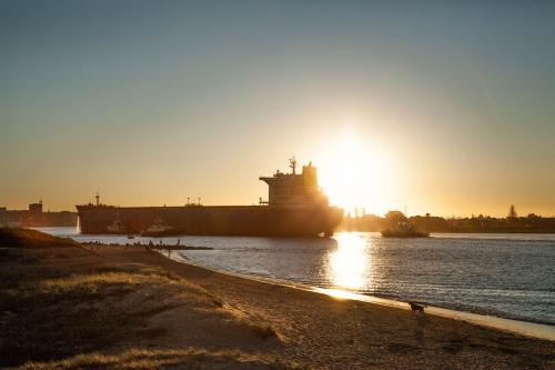 Coal ship coming into Newcastle Harbour at sunset - Australian Stock Image