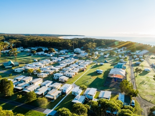 Coastal holiday caravan park in morning light with rows of cabins - Australian Stock Image