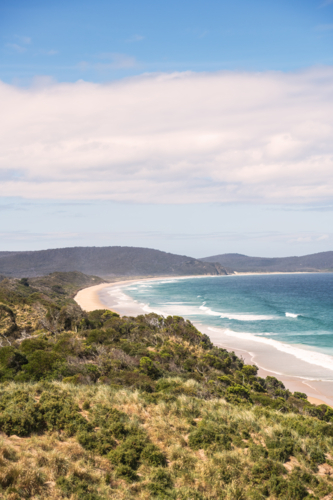 Coastal long shot of white sandy beach with surf - Australian Stock Image
