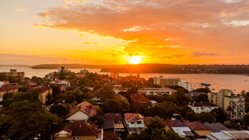 coastal town and bay at vibrant sunset - Australian Stock Image