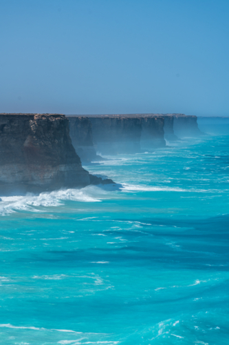 Coastal vista of towering, rugged cliffs in an open sea. - Australian Stock Image