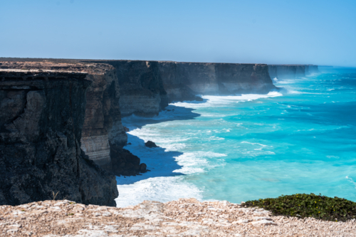 Coastal vista of towering, rugged cliffs in an open sea. - Australian Stock Image