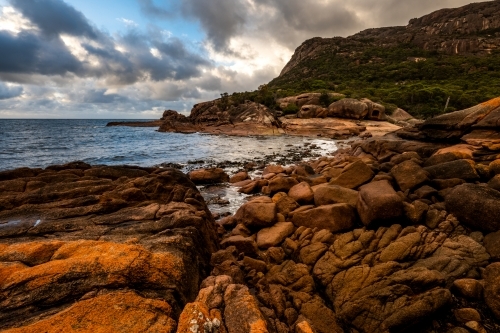 Coastline with red rocks and cloudy sky
