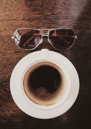 Coffee and sunglasses on table