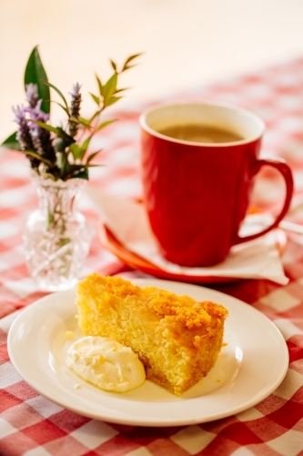 Coffee cake and flowers on checkered table cloth