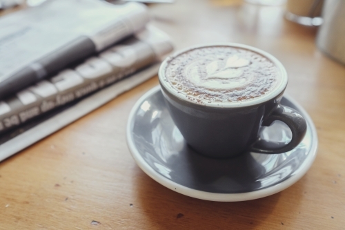 Coffee latte with newspaper - Australian Stock Image