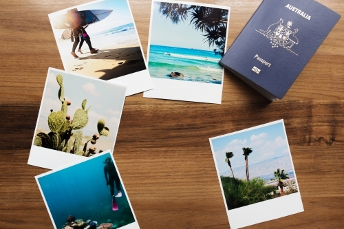 Collection of travel photographs and Australian passport flat lay