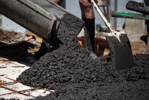 Coloured cement concrete pouring out of chute - Australian Stock Image