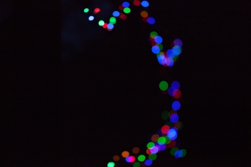 Coloured fairy lights on a black background - Australian Stock Image