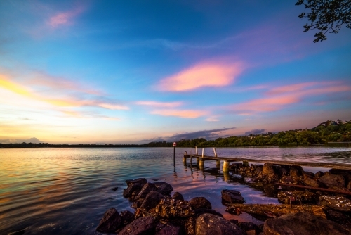 Coloured sky in the dawn morning looking over Tweed river with the jetty in the frame. - Australian Stock Image