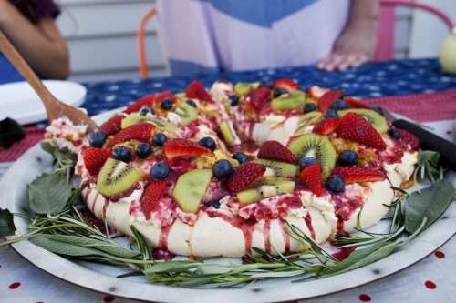 Colourful Christmas pavlova on table being served - Australian Stock Image