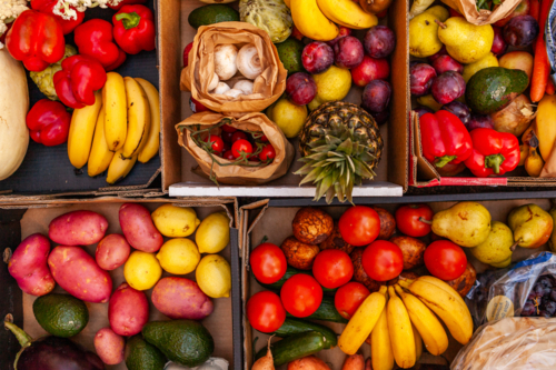 Colourful overhead angle of fresh organic fruit and vegetable boxes at unsupermarket food hub - Australian Stock Image