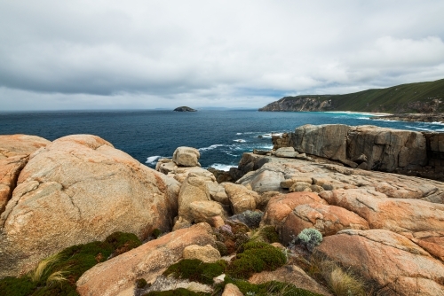 Colourful rocky foreshore on Southern Ocean with stormy sky