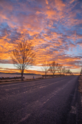 Colourful sunrise skies over a country road - Australian Stock Image