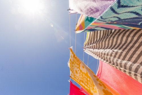 Colourful towels and swimmers hanging on washing line - Australian Stock Image
