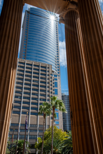 Columns of the State Library with modern glass building behind with a starburst - Australian Stock Image