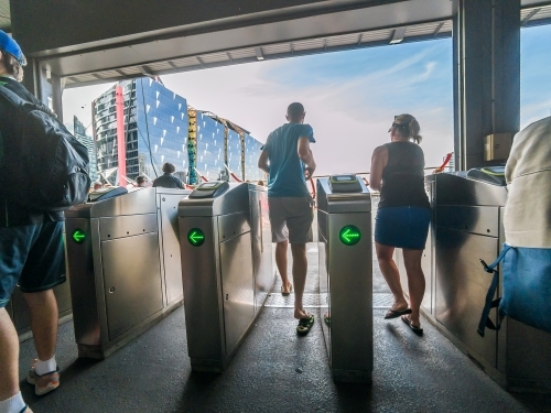 Commuters rushing through entrance barriers at a railway stations - Australian Stock Image
