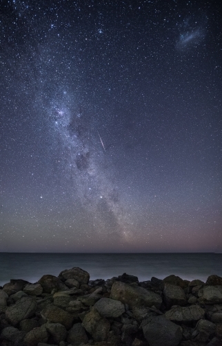 Constellation over ocean with rocks in foreground. - Australian Stock Image