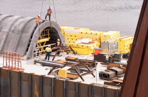 Construction of a building extension on the side of a river - Australian Stock Image