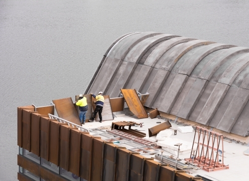 Construction of a building extension on the side of a river - Australian Stock Image