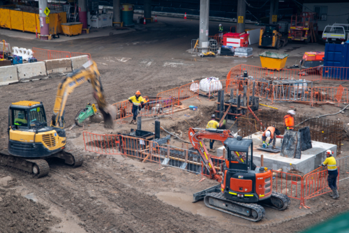 Construction site with machinery and workers in high-vis - Australian Stock Image