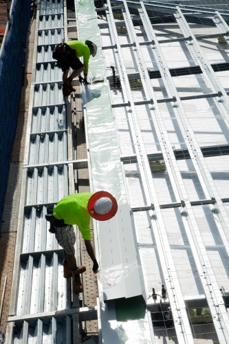 Construction workers with metal framework on an industrial building site - Australian Stock Image
