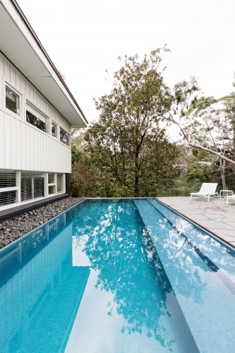 Contemporary fully tiled swimming pool in mid century modern Australian home - Australian Stock Image