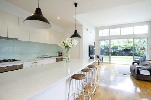 Contemporary kitchen and living room with bar stools - Australian Stock Image