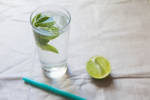 Cool glass of water with ice and mint on tabletop - Australian Stock Image
