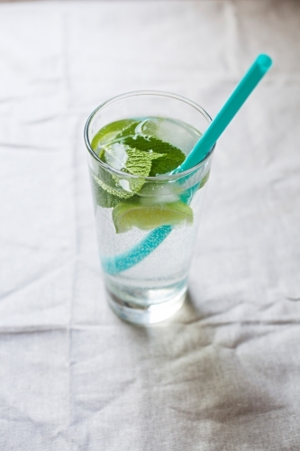 Cool glass of water with ice and mint on tabletop