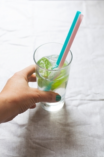 Cool glass of water with ice and mint on tabletop - Australian Stock Image