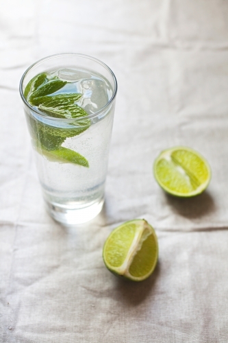 Cool glass of water with ice and mint on tabletop - Australian Stock Image