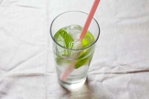 Cool glass of water with ice and mint on tabletop - Australian Stock Image