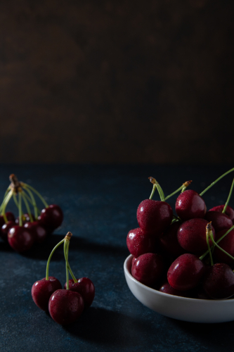 copy space above red cherries on a plate - Australian Stock Image