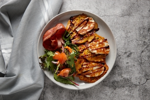 Corn frittata topped with mozzarella cheese with vegetable salad and bacon on the side. - Australian Stock Image
