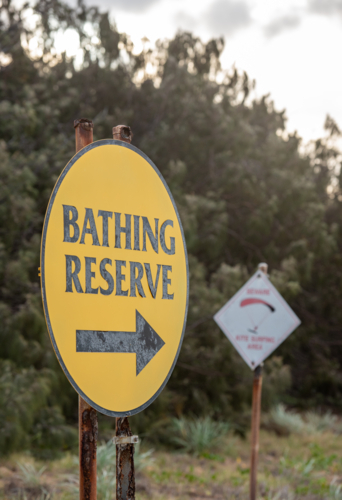 corroded bathing reserve sign on Tannum Sands beach - Australian Stock Image