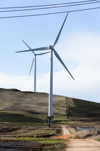 Country road leading past wind turbines - Australian Stock Image